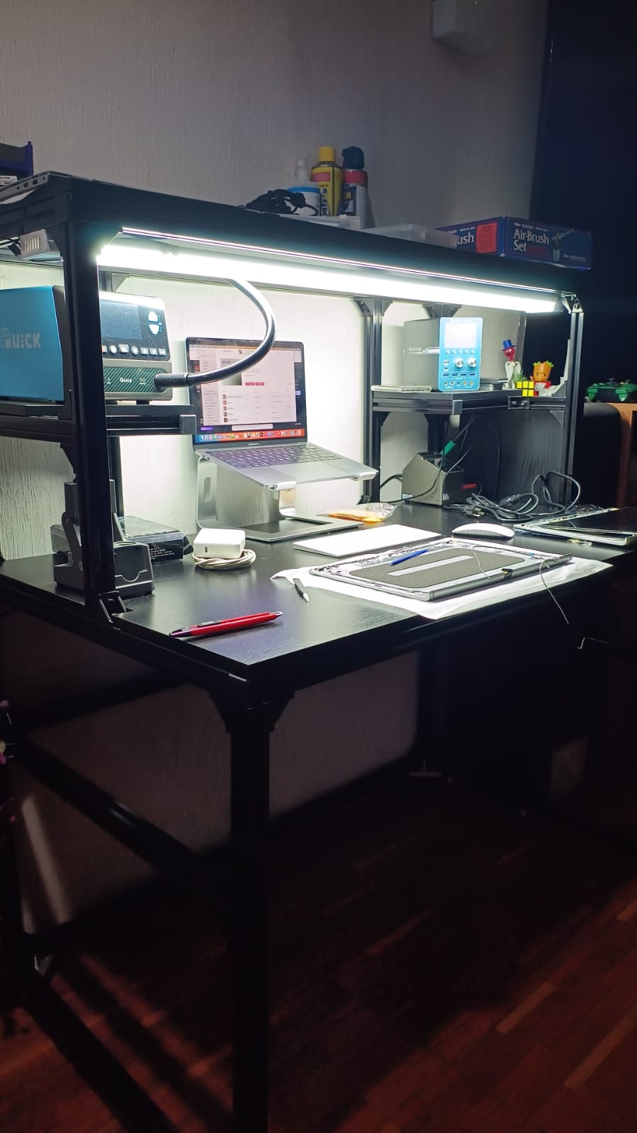 Estación de trabajo del taller WFG Solutions: mesa con iluminación LED, estación de soldadura y una MacBook en reparación